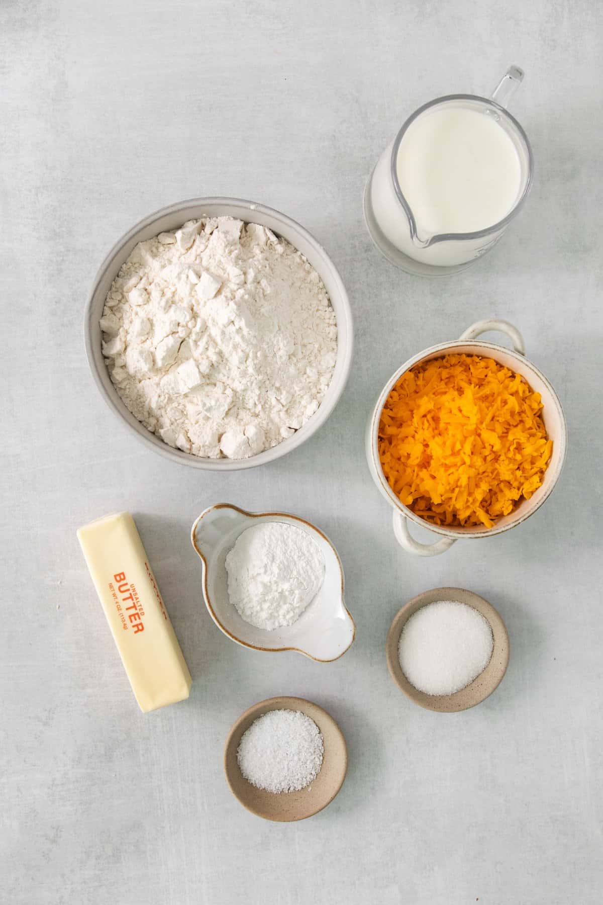 ingredients for a carrot cake on a grey background.