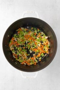 a pan with vegetables in it on a white surface.