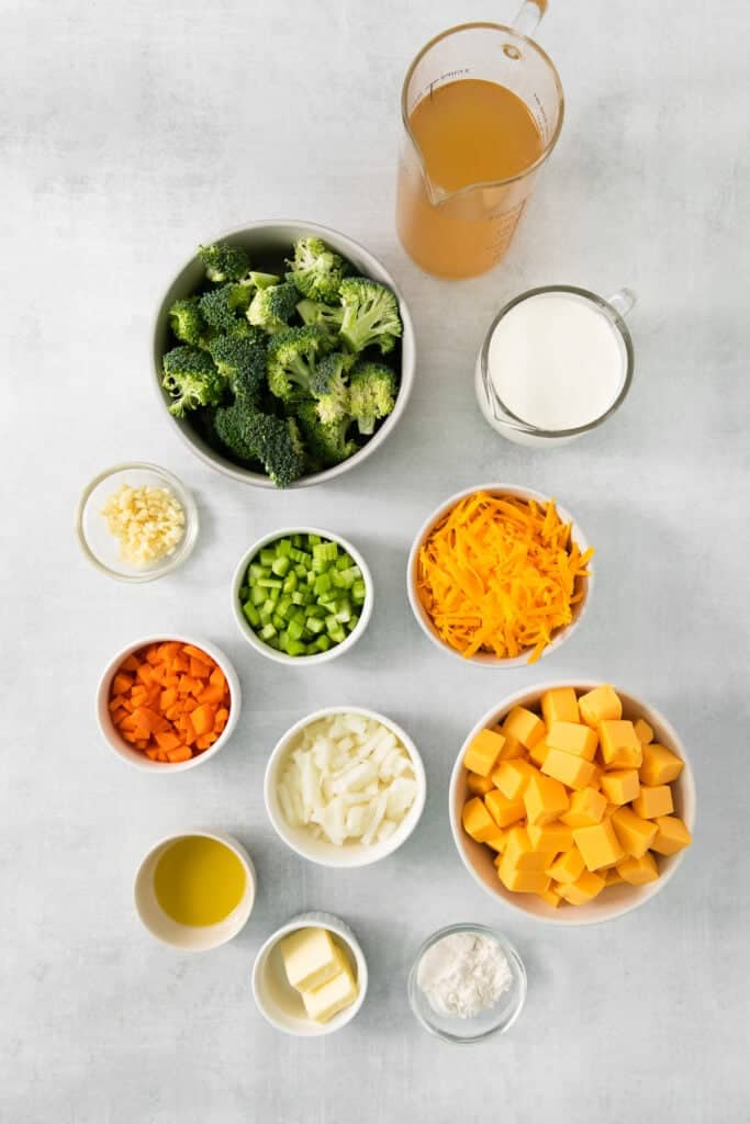 a bowl of broccoli, carrots, cheese and milk.
