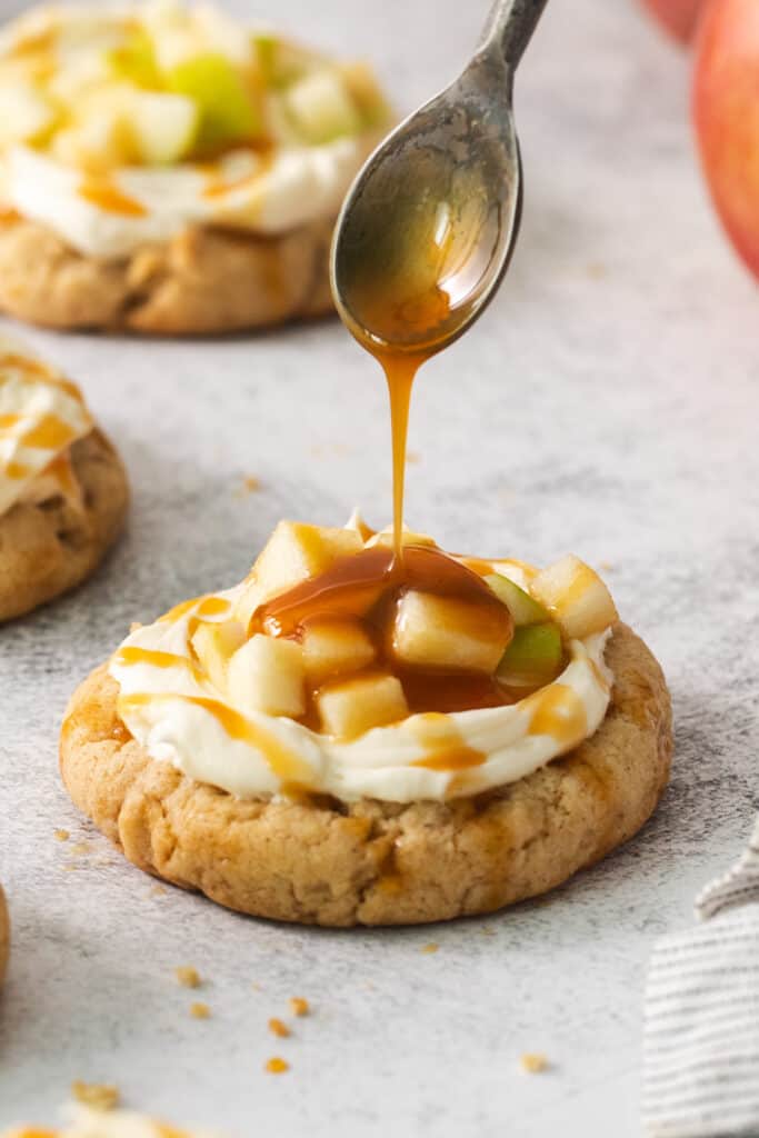a spoon drizzling caramel on a cookie.