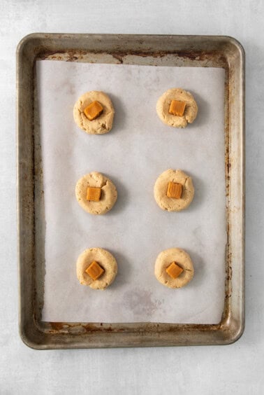 a baking sheet with six cookies on it.