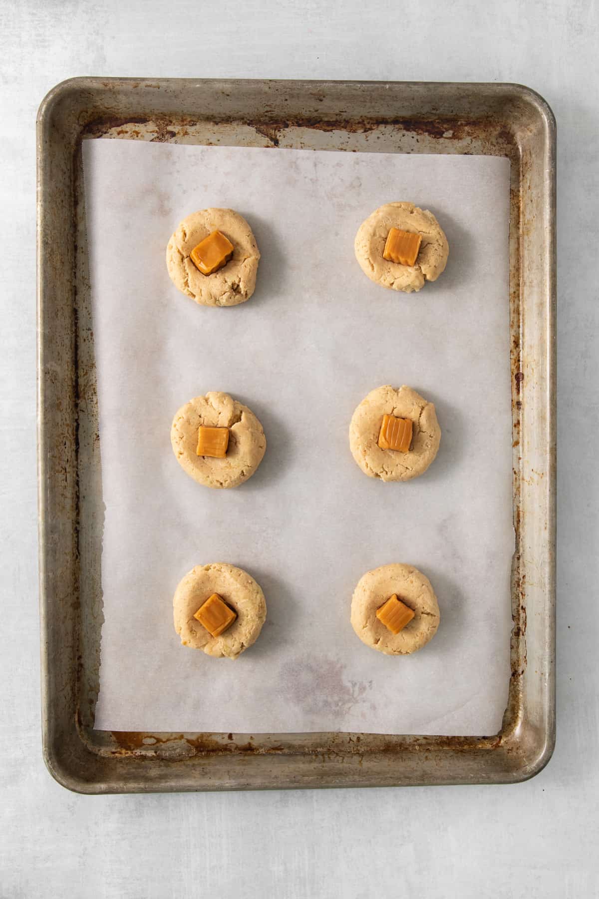 a baking sheet with six cookies on it.