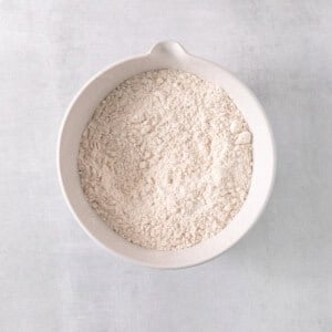 a white bowl filled with white powder on top of a table.