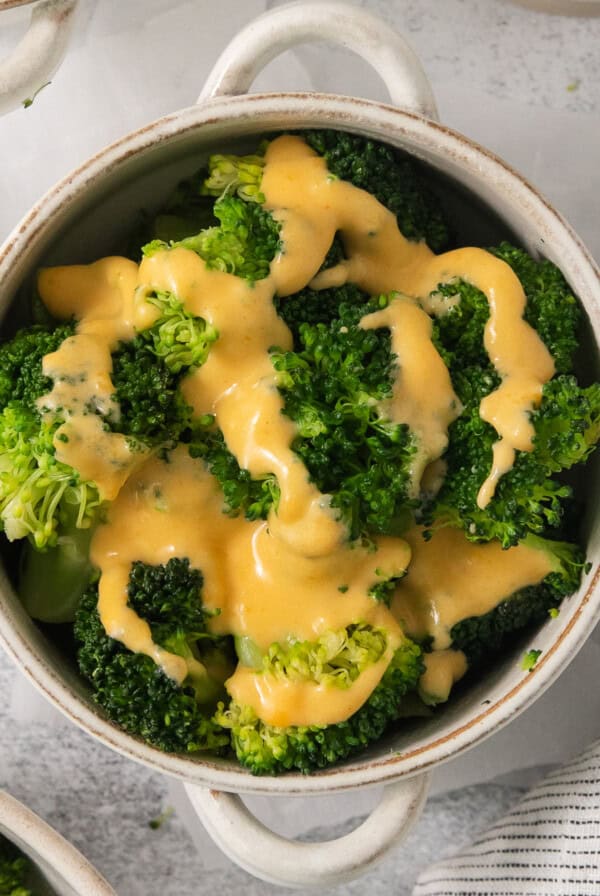 a pot filled with broccoli covered in cheese.