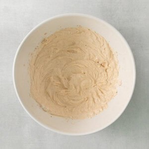 a white bowl filled with batter on top of a table.