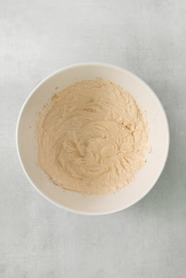 a white bowl filled with batter on top of a table.