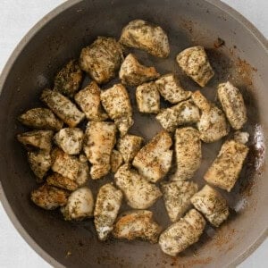 fried chicken in a skillet on a white surface.