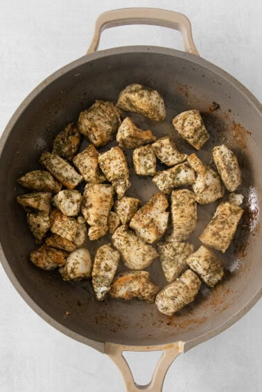 fried chicken in a skillet on a white surface.