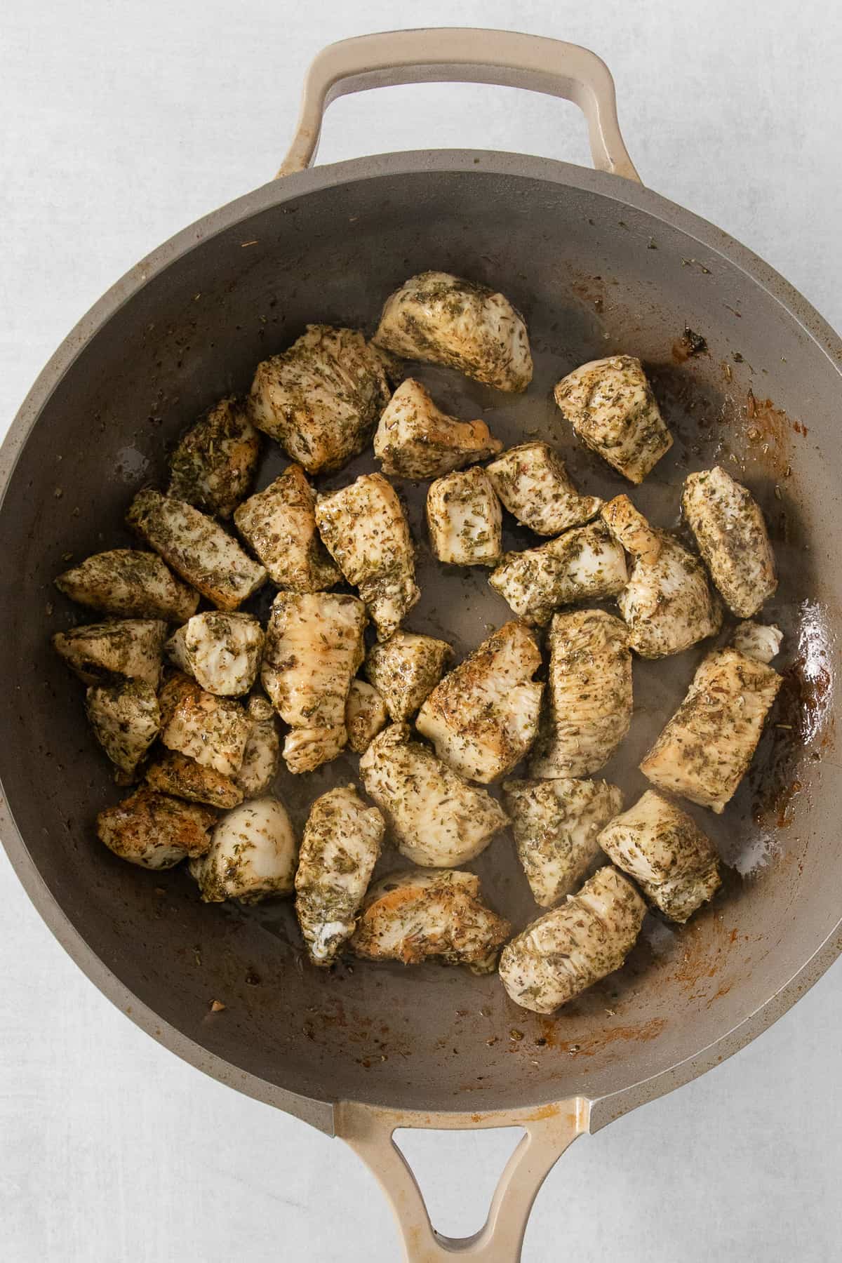 fried chicken in a skillet on a white surface.