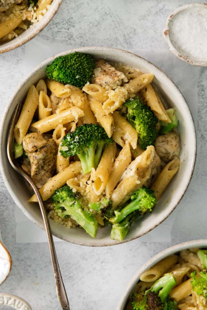 a bowl of pasta with meat and broccoli.