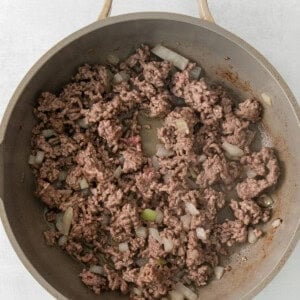 a skillet filled with ground beef and onions.