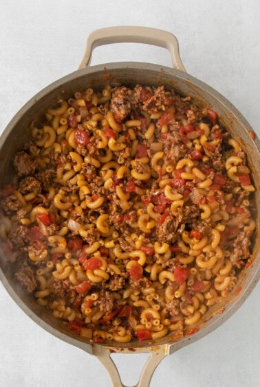 a pan full of pasta and meat in a skillet.