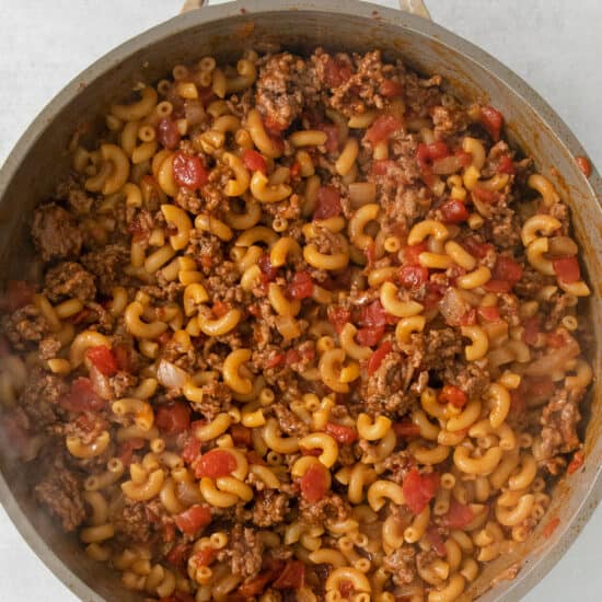 a pan full of pasta and meat in a skillet.