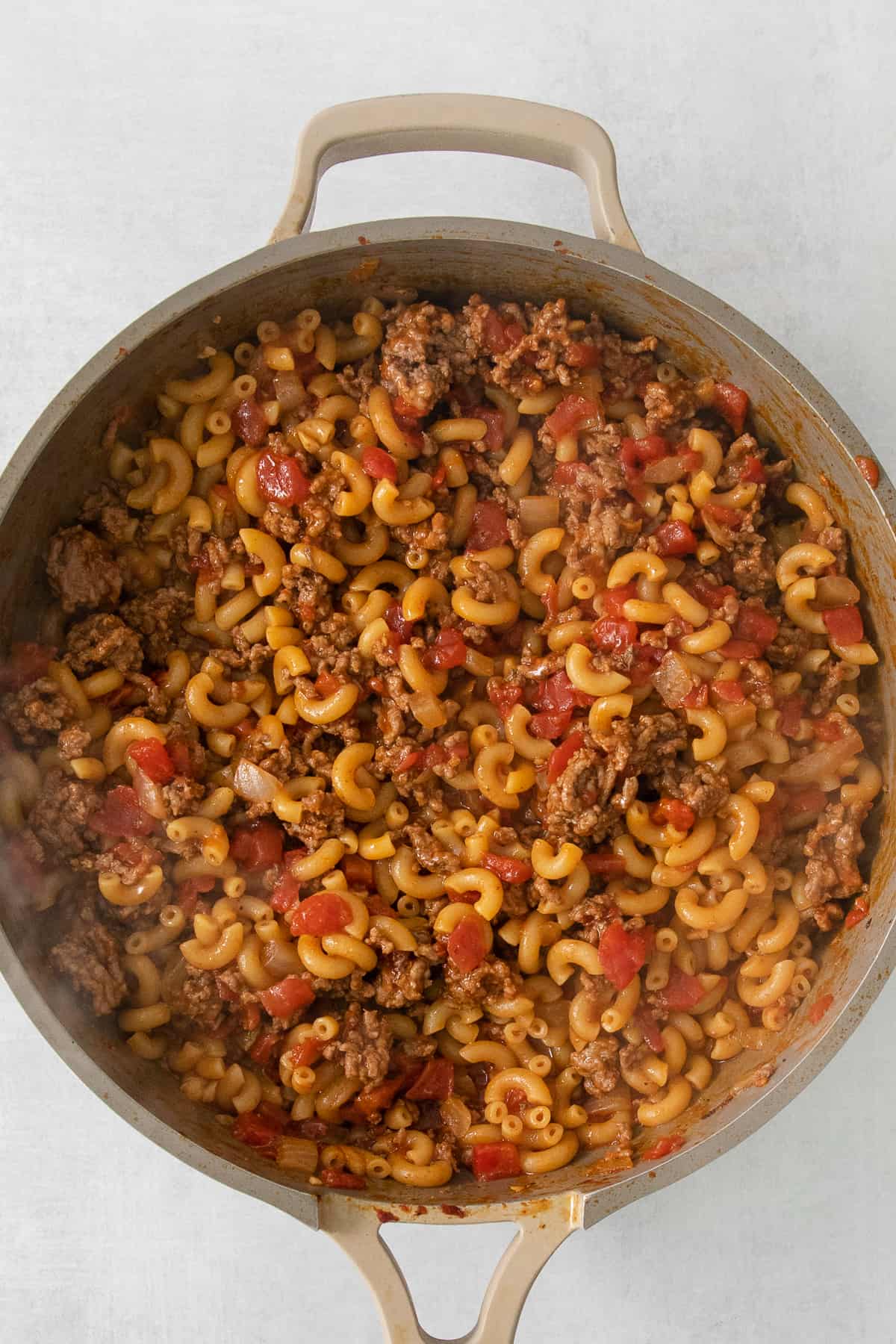 a pan full of pasta and meat in a skillet.