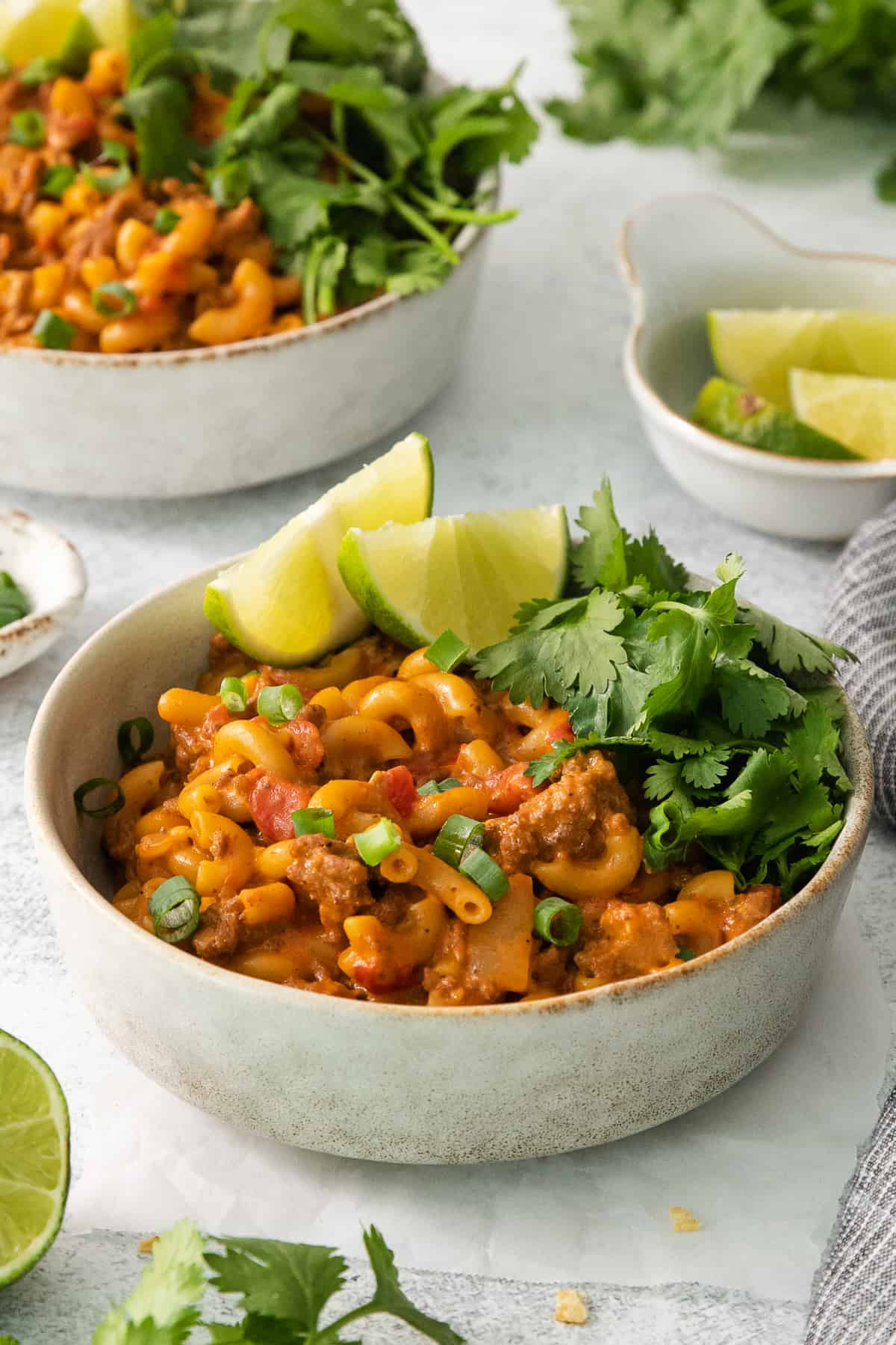 two bowls of pasta with meat and vegetables.