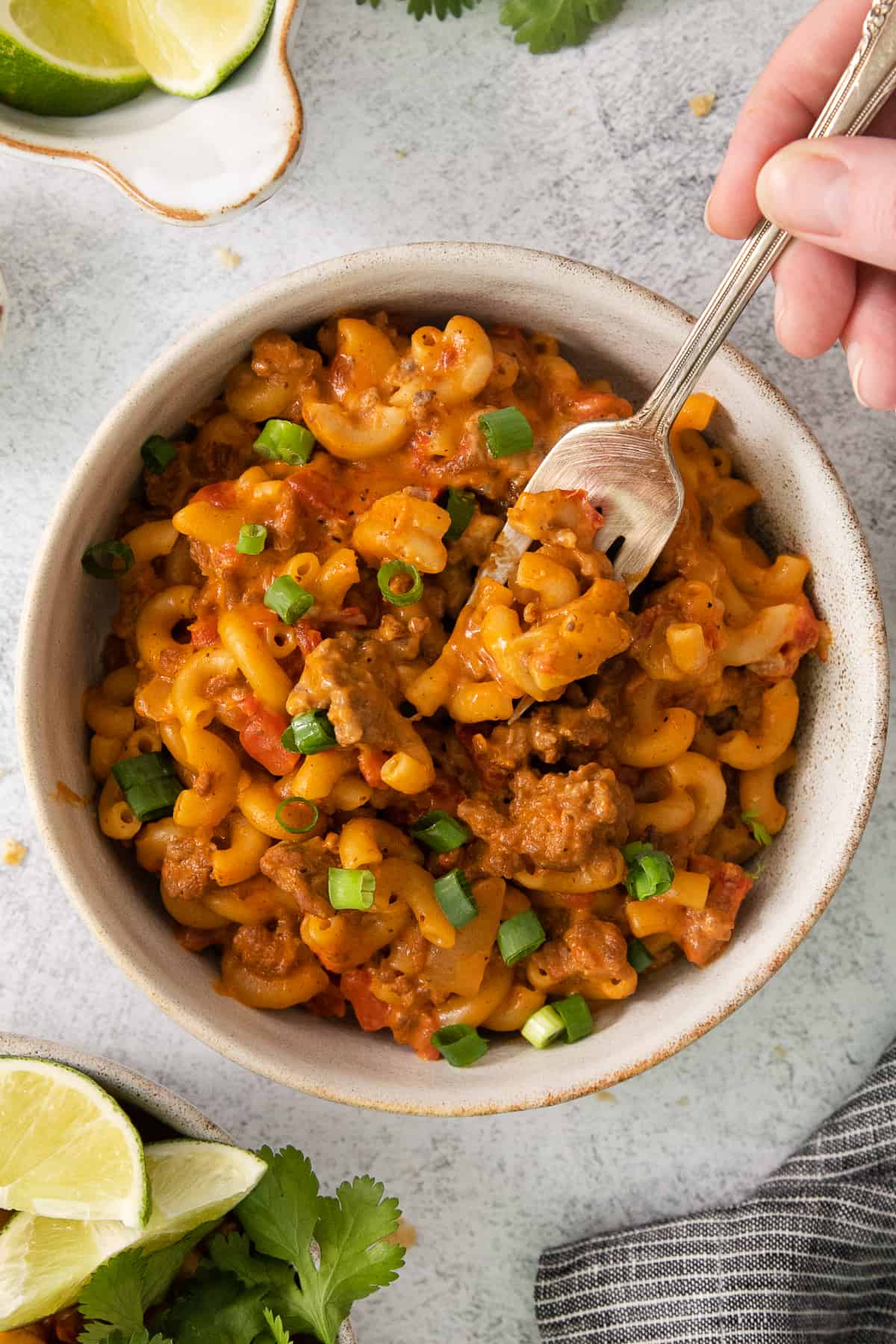 a bowl of mexican macaroni and cheese with a spoon.