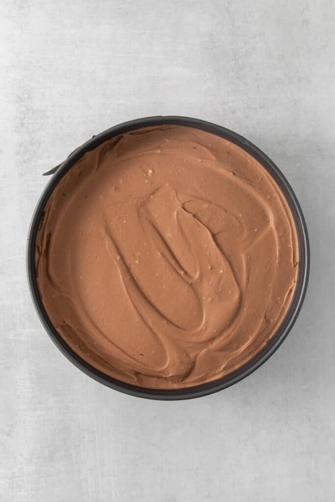 a bowl filled with chocolate frosting on top of a table.