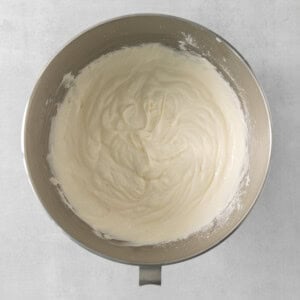 a bowl of cream sitting on top of a table.