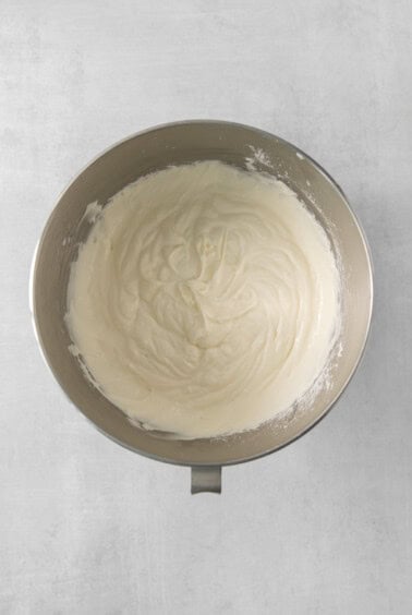 a bowl of cream sitting on top of a table.