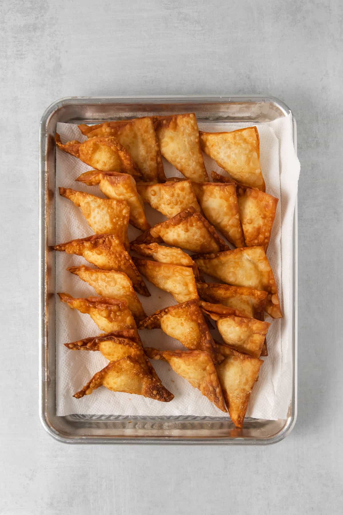 Cream cheese rangoon on a baking sheet.