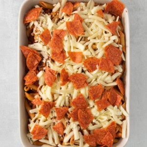 a casserole dish filled with pepperoni and cheese.