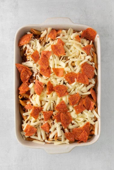 a casserole dish filled with pepperoni and cheese.