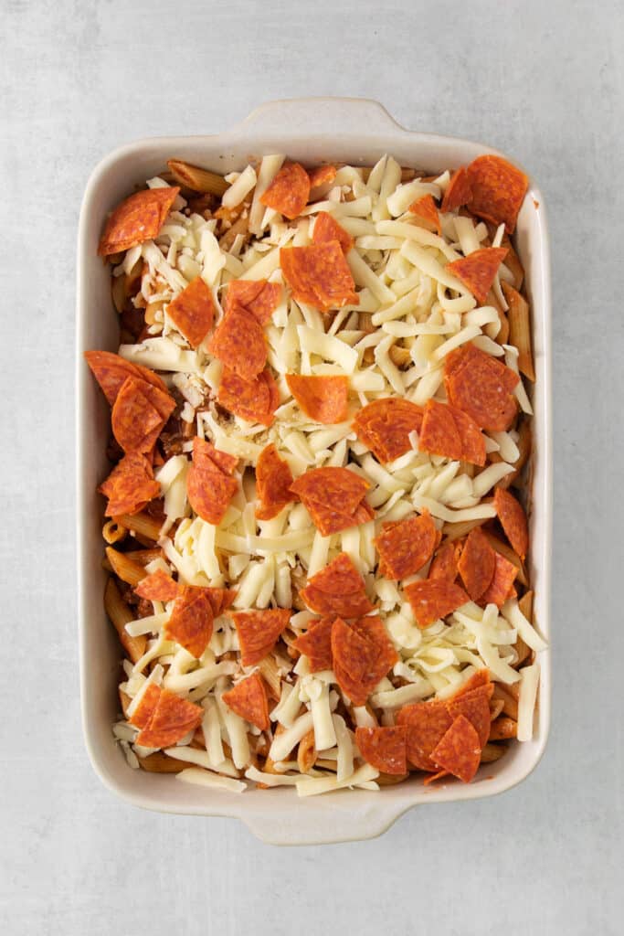 a casserole dish filled with pepperoni and cheese.