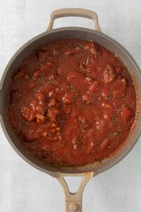 a pan full of tomato sauce with meat in it.