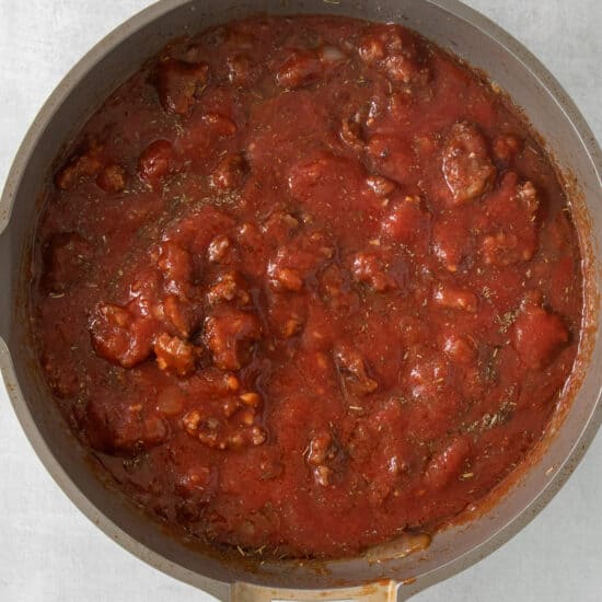 a pan full of tomato sauce with meat in it.