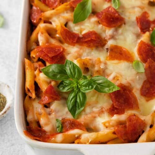 a casserole dish with pepperoni and cheese.