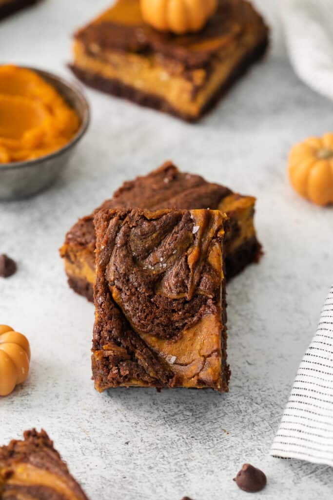 a slice of pumpkin swirl brownies on a grey background.