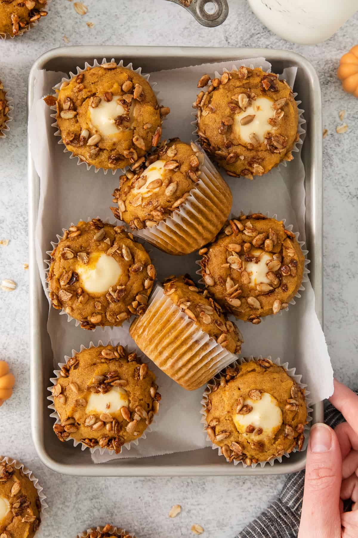 pumpkin cheesecake muffins on a baking sheet.