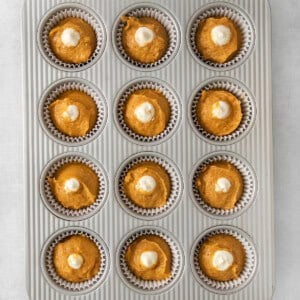 pumpkin cupcakes in a muffin tin.