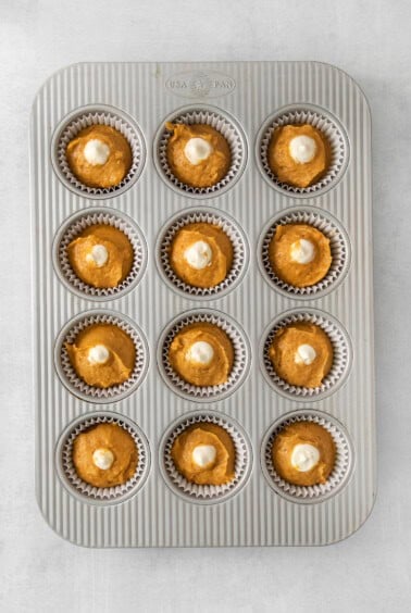 pumpkin cupcakes in a muffin tin.