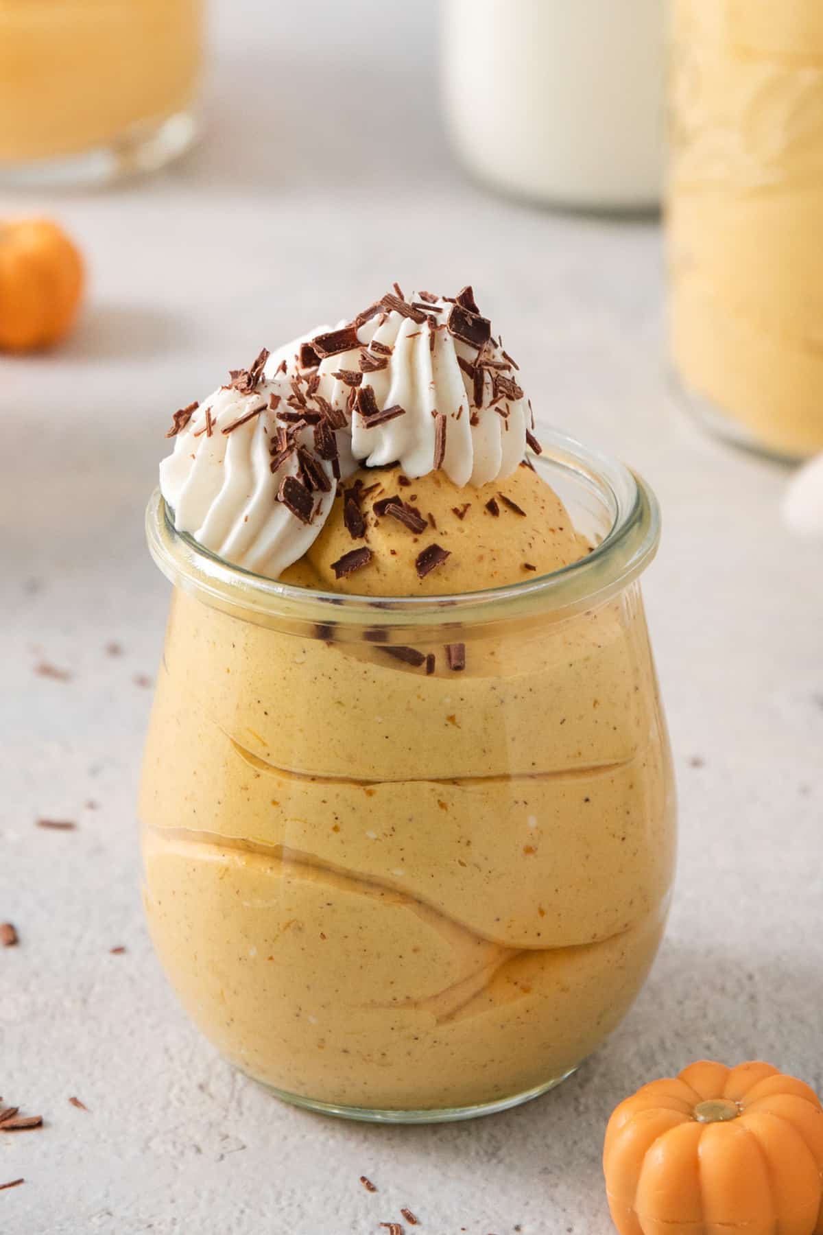 a dessert in a glass jar with whipped cream on top.