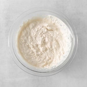 a bowl filled with cream sitting on top of a table.