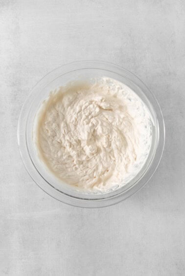 a bowl filled with cream sitting on top of a table.