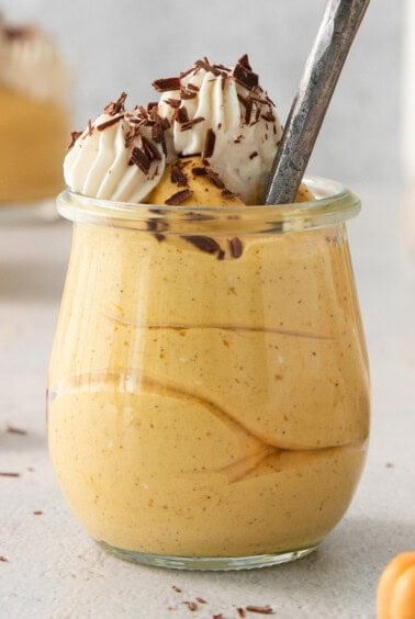 a dessert in a jar with a spoon in it.