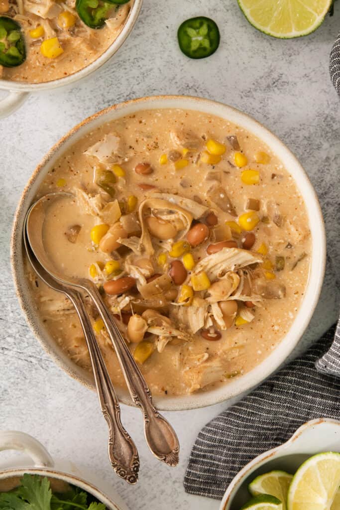 mexican chicken chowder in a bowl with limes and corn.