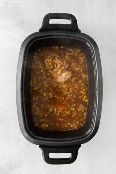 a slow cooker filled with meat and vegetables.