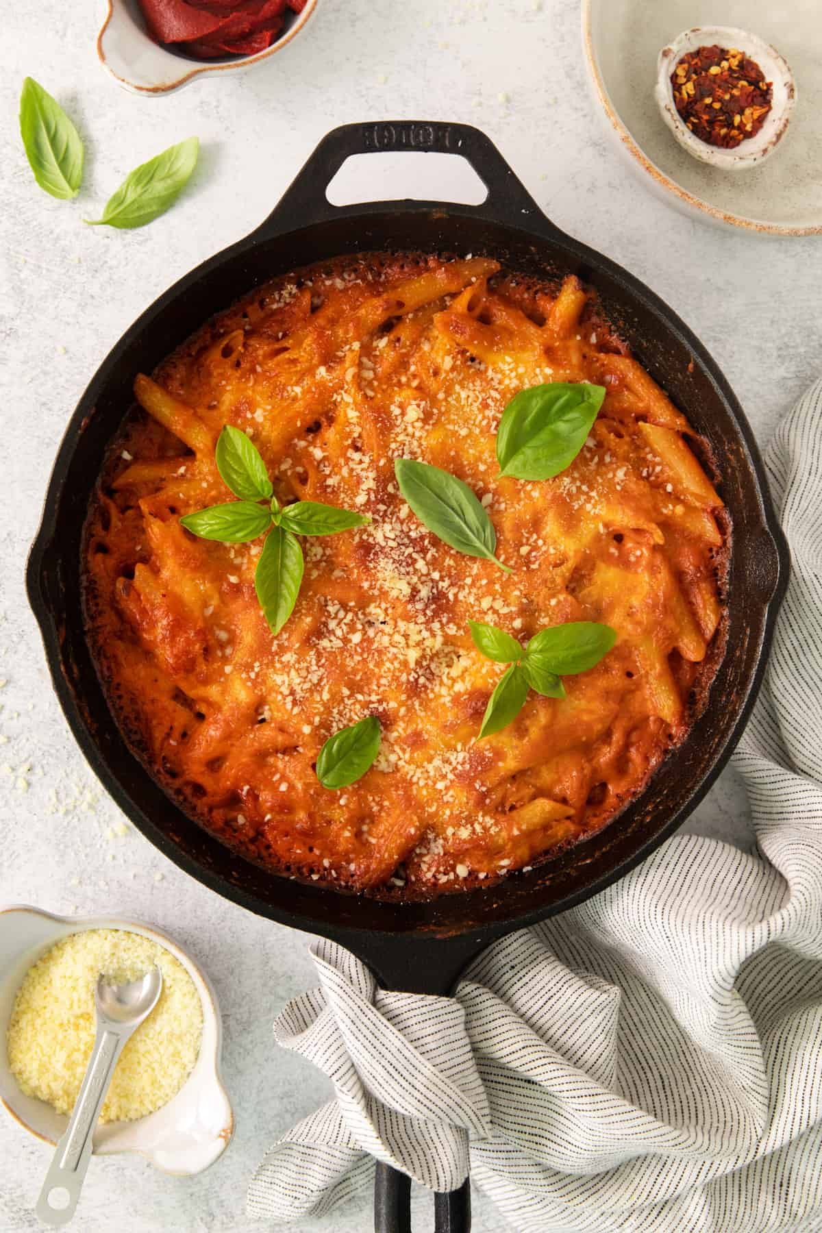 a skillet filled with pasta and sauce on top of a table.