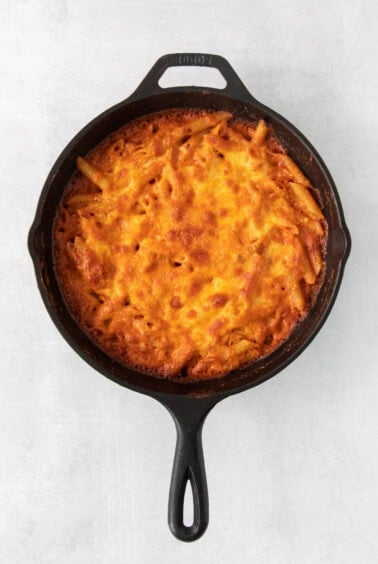 a skillet with a cheesy dish inside of it.