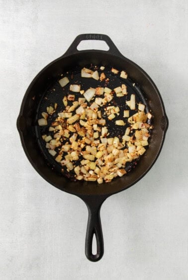 a frying pan filled with chopped vegetables on top of a table.