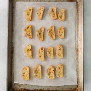 a baking sheet with sliced bread on it.