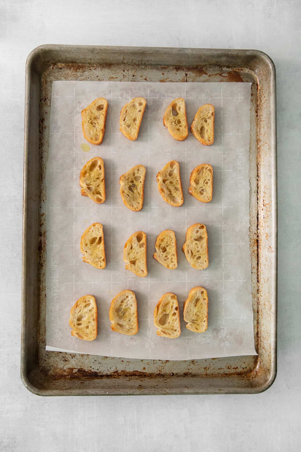 a baking sheet with sliced bread on it.