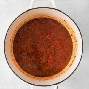 a pot full of tomato sauce on a white background.