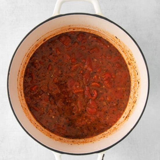 a pot full of tomato sauce on a white background.