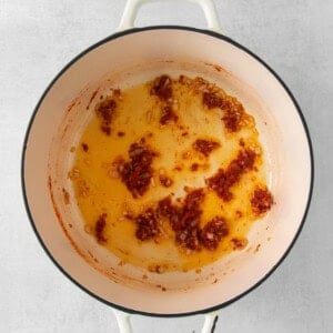 a pot with a sauce in it on a white background.