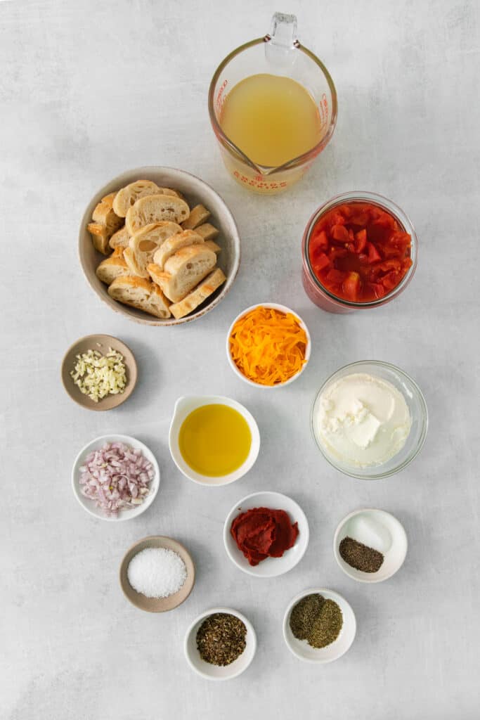 the ingredients for a pizza are laid out on a table.