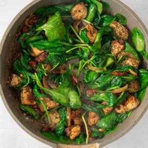 a pan with spinach and tofu in it.